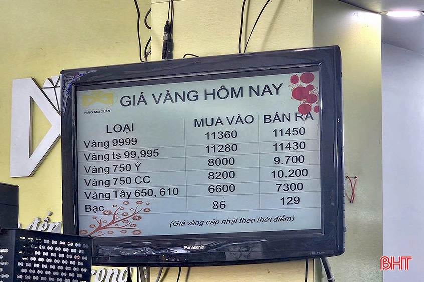 Người dân xem giá vàng tại cửa hàng